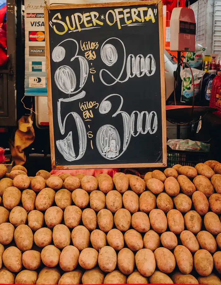 Letrero de venta de papas en feria libre